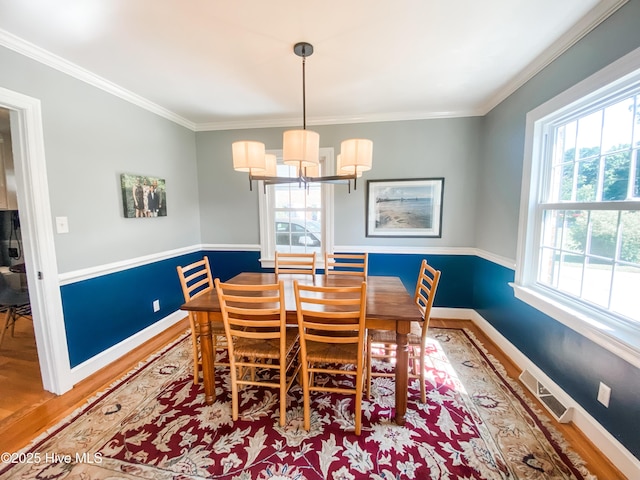 1721 Nash St NW, Wilson, NC 27893 - dining room featuring wood finished floors, ornamental molding, and a chandelier