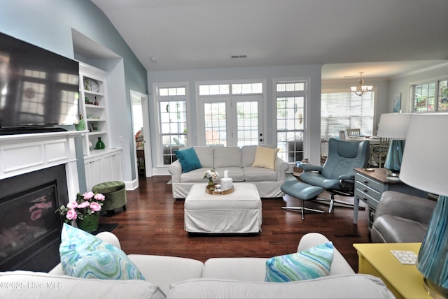 4875 Frasier Cir, Shallotte, NC 28470 - living room featuring a chandelier, wood finished floors, lofted ceiling, and a glass covered fireplace