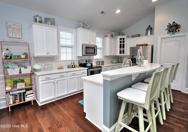 4875 Frasier Cir, Shallotte, NC 28470 - kitchen with stainless steel appliances, glass insert cabinets, white cabinetry, light countertops, and a kitchen island with sink