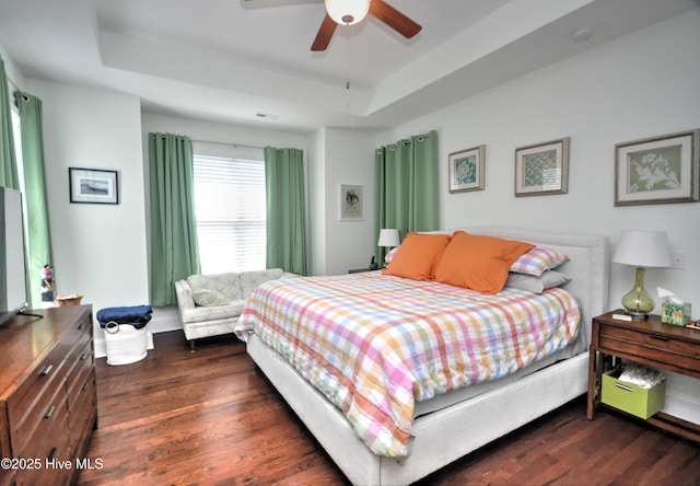 4875 Frasier Cir, Shallotte, NC 28470 - bedroom with a tray ceiling, dark wood-type flooring, and a ceiling fan