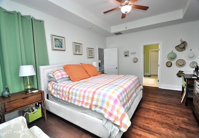 4875 Frasier Cir, Shallotte, NC 28470 - bedroom with a tray ceiling, wood finished floors, and a ceiling fan