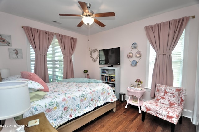 4875 Frasier Cir, Shallotte, NC 28470 - bedroom featuring multiple windows, dark wood-style flooring, and a ceiling fan
