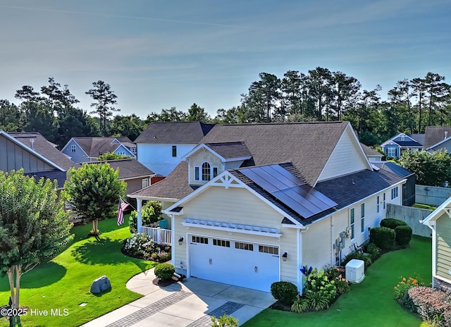 4875 Frasier Cir, Shallotte, NC 28470 - view of front of house with concrete driveway, an attached garage, roof with shingles, and solar panels