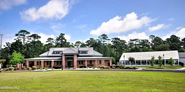 4875 Frasier Cir, Shallotte, NC 28470 - view of front of house with a front lawn, a metal roof, view of wooded area, and a standing seam roof