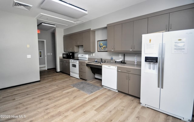 4875 Frasier Cir, Shallotte, NC 28470 - kitchen featuring white appliances, light wood-style floors, and gray cabinetry