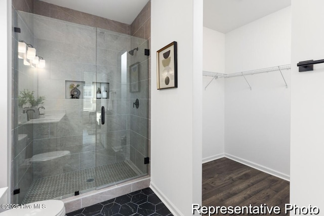 1664 Greenside Ct SW Unit 77, Ocean Isle Beach, NC 28469 - bathroom with a shower stall, a walk in closet, and wood finished floors