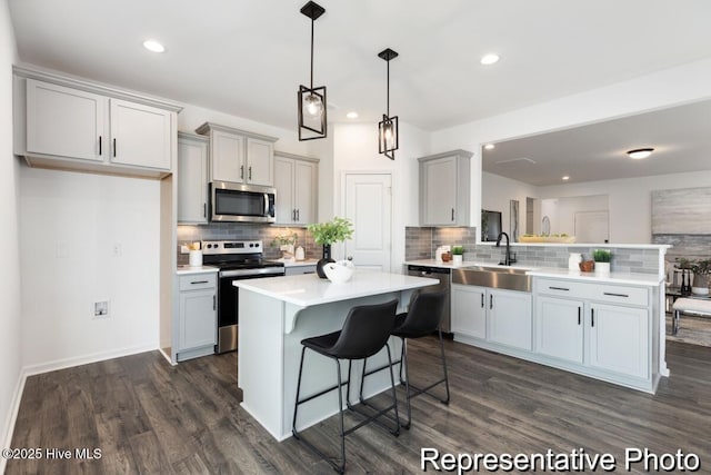 1664 Greenside Ct SW Unit 77, Ocean Isle Beach, NC 28469 - kitchen featuring stainless steel appliances, a peninsula, dark wood-style floors, backsplash, and light countertops