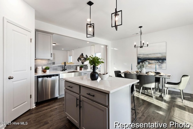 1664 Greenside Ct SW Unit 77, Ocean Isle Beach, NC 28469 - kitchen with dishwasher, gray cabinetry, dark wood-type flooring, tasteful backsplash, and a chandelier