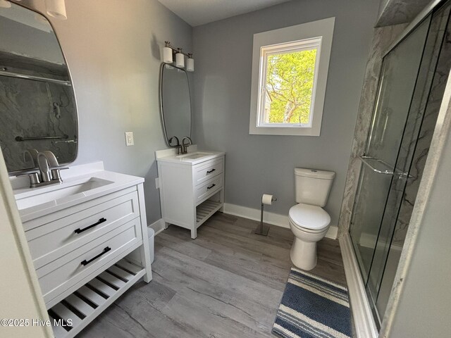 31 Augusta Dr, Oak Island, NC 28465 - bathroom featuring two vanities, a marble finish shower, and wood finished floors