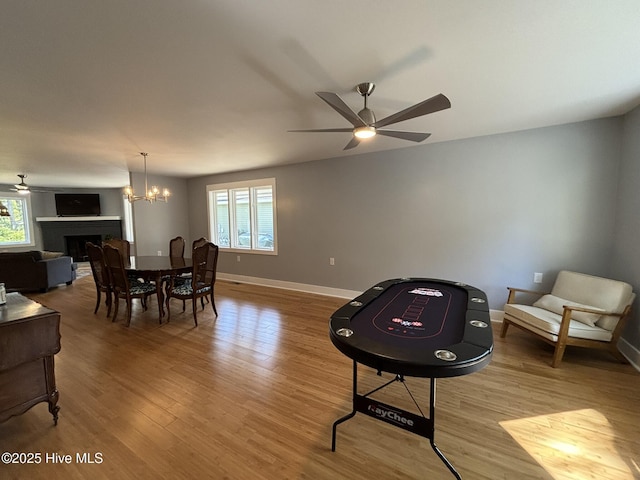 31 Augusta Dr, Oak Island, NC 28465 - dining area featuring a ceiling fan, wood finished floors, a fireplace, and a chandelier
