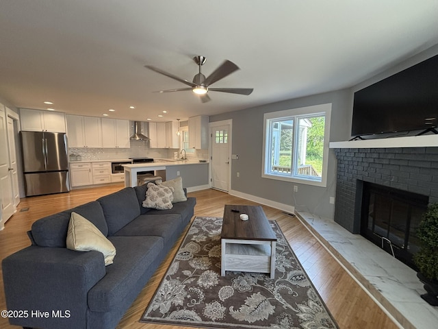 31 Augusta Dr, Oak Island, NC 28465 - living area with a brick fireplace, a ceiling fan, light wood-type flooring, and recessed lighting