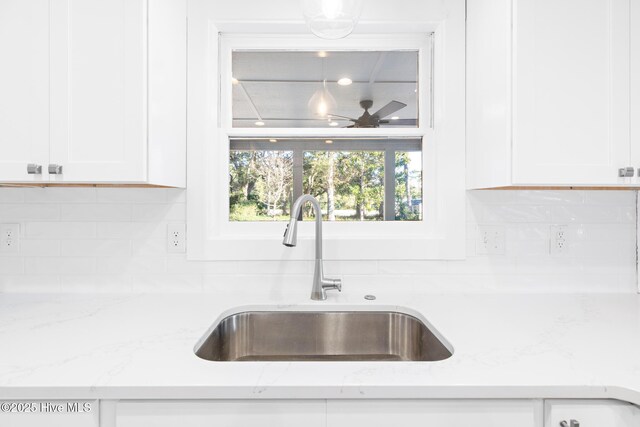 31 Augusta Dr, Oak Island, NC 28465 - kitchen with white cabinets, backsplash, a ceiling fan, and light stone countertops