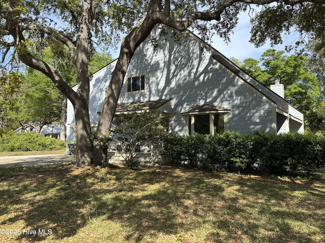 31 Augusta Dr, Oak Island, NC 28465 - view of property exterior with a chimney and a lawn