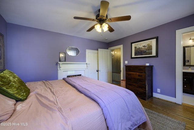 507 Blades Ave, New Bern, NC 28560 - bedroom with wood finished floors, a fireplace, ensuite bath, and ceiling fan