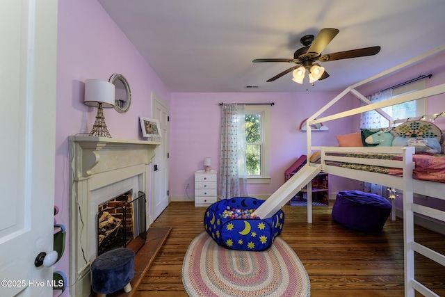 507 Blades Ave, New Bern, NC 28560 - bedroom with wood finished floors, a fireplace with flush hearth, and a ceiling fan