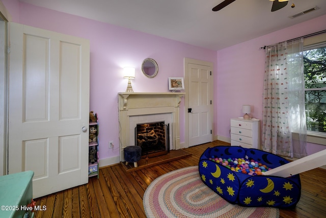 507 Blades Ave, New Bern, NC 28560 - bedroom featuring a fireplace with raised hearth, wood finished floors, and a ceiling fan