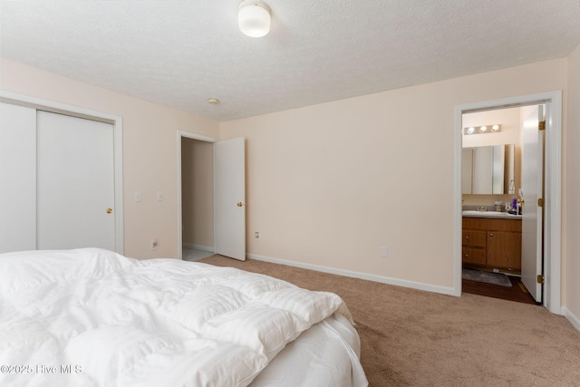 1901 Hess St, Wilmington, NC 28411 - bedroom with light colored carpet, connected bathroom, a textured ceiling, and a closet