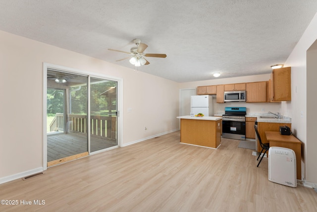1901 Hess St, Wilmington, NC 28411 - kitchen with stainless steel appliances, a center island, light wood-style floors, light countertops, and ceiling fan