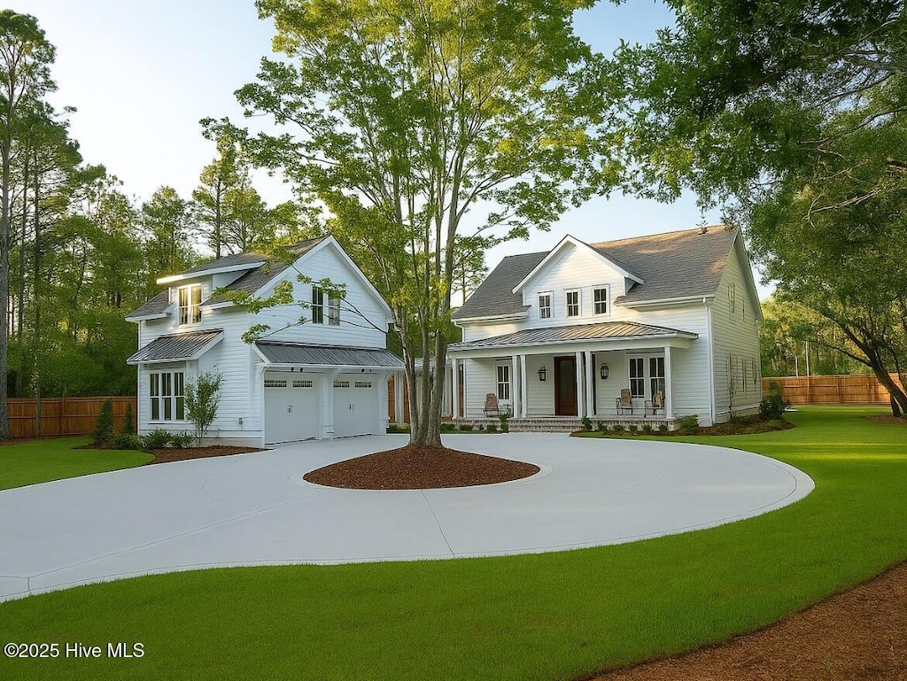 343 Pages Creek Rd, Wilmington, NC 28411 - view of front of home with a porch, an attached garage, a metal roof, concrete driveway, and a standing seam roof