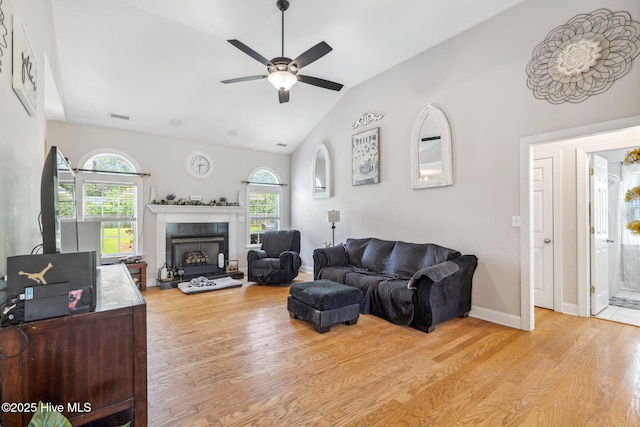 820 Jackeys Creek Ln SE, Leland, NC 28451 - living room featuring light wood-type flooring, a ceiling fan, vaulted ceiling, and a tiled fireplace