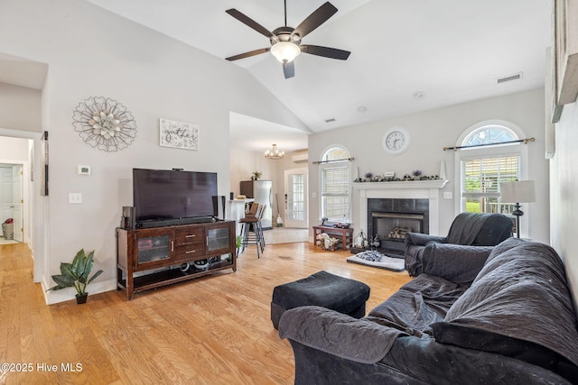 820 Jackeys Creek Ln SE, Leland, NC 28451 - living room featuring ceiling fan, lofted ceiling, a tiled fireplace, light wood-style floors, and a chandelier