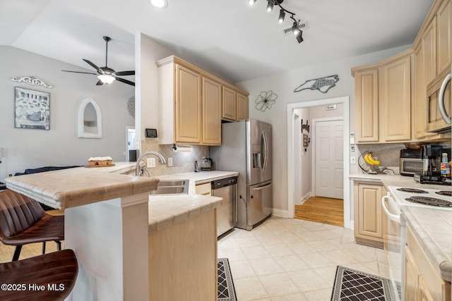 820 Jackeys Creek Ln SE, Leland, NC 28451 - kitchen featuring stainless steel appliances, tile counters, a peninsula, ceiling fan, and light brown cabinets