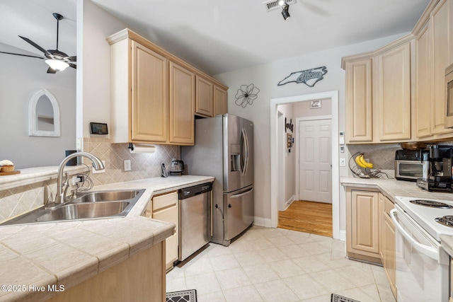 820 Jackeys Creek Ln SE, Leland, NC 28451 - kitchen featuring appliances with stainless steel finishes, ceiling fan, tile counters, light brown cabinetry, and backsplash
