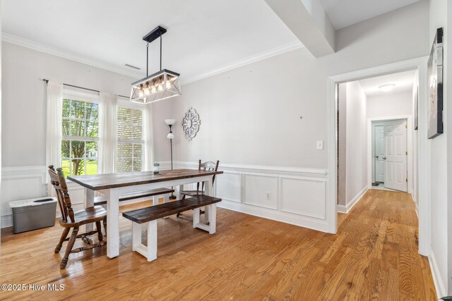 820 Jackeys Creek Ln SE, Leland, NC 28451 - dining space with wainscoting, a chandelier, light wood-style floors, ornamental molding, and a decorative wall