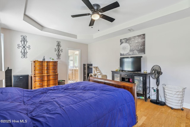 820 Jackeys Creek Ln SE, Leland, NC 28451 - bedroom featuring wood finished floors, a raised ceiling, ensuite bath, and ceiling fan