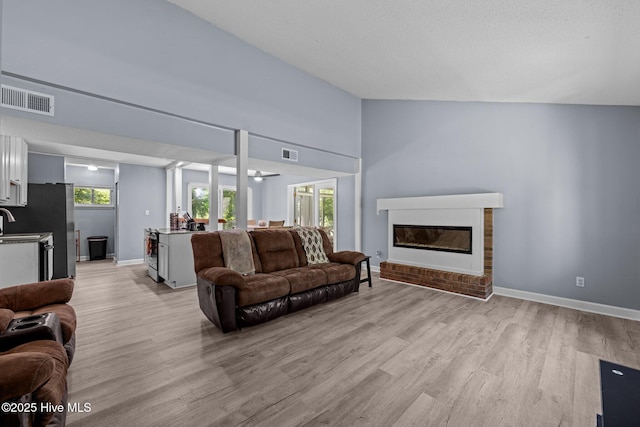 120 Croatan Ln, New Bern, NC 28562 - living area with light wood finished floors, a glass covered fireplace, and lofted ceiling