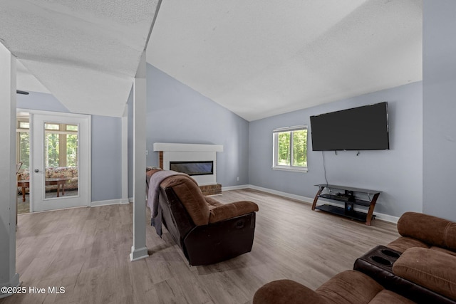 120 Croatan Ln, New Bern, NC 28562 - living room featuring lofted ceiling, light wood-style flooring, a fireplace, and a textured ceiling