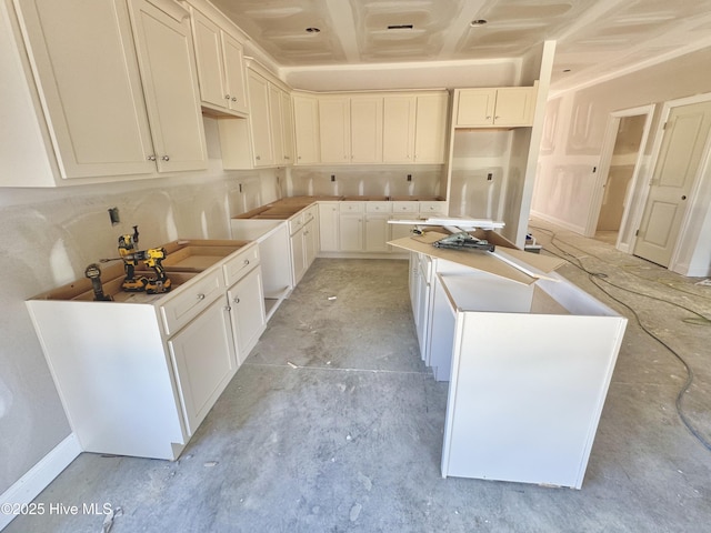 919 Albrittons Rd, Kinston, NC 28504 - kitchen featuring a kitchen island, concrete floors, and white cabinetry