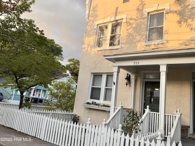 228 Mcrae St, Wilmington, NC 28401 - view of front of house with stucco siding and a fenced front yard