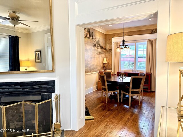 228 Mcrae St, Wilmington, NC 28401 - dining room featuring hardwood / wood-style floors, crown molding, ceiling fan, a chandelier, and a glass covered fireplace