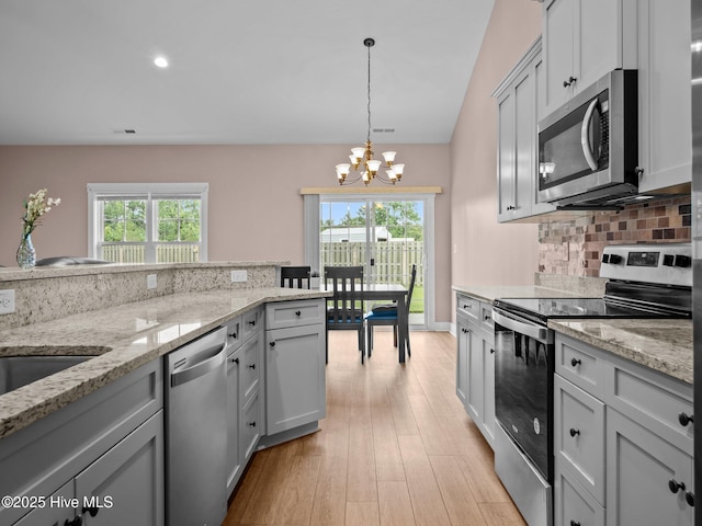 500 Perth Ct, Hubert, NC 28539 - kitchen featuring appliances with stainless steel finishes, a chandelier, tasteful backsplash, hanging light fixtures, and light wood-type flooring