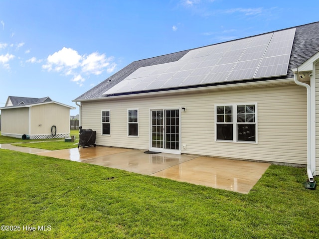500 Perth Ct, Hubert, NC 28539 - back of property with roof mounted solar panels, a lawn, a patio, and roof with shingles