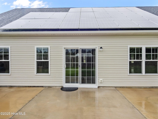 500 Perth Ct, Hubert, NC 28539 - back of property with roof mounted solar panels, a patio, and roof with shingles