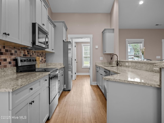 500 Perth Ct, Hubert, NC 28539 - kitchen featuring stainless steel appliances, light wood-style flooring, backsplash, a peninsula, and gray cabinets