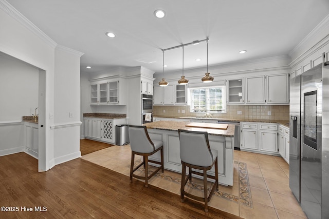 3902 Kipling Ct, Greenville, NC 27834 - kitchen with appliances with stainless steel finishes, a kitchen island, light stone countertops, backsplash, and recessed lighting