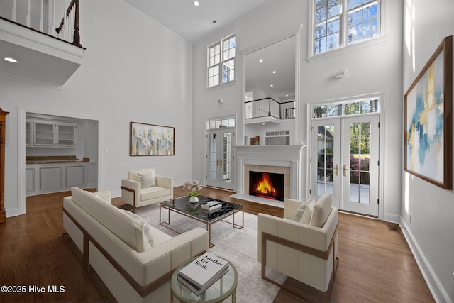 3902 Kipling Ct, Greenville, NC 27834 - living room with a towering ceiling, french doors, wood finished floors, a warm lit fireplace, and ornamental molding