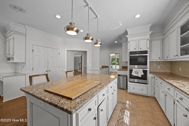 3902 Kipling Ct, Greenville, NC 27834 - kitchen featuring stainless steel double oven, a kitchen island, recessed lighting, backsplash, and ornamental molding