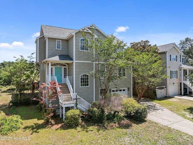 9406 Voyagers Way, Wilmington, NC 28412 - view of front facade featuring stairs, driveway, an attached garage, a shingled roof, and a front yard