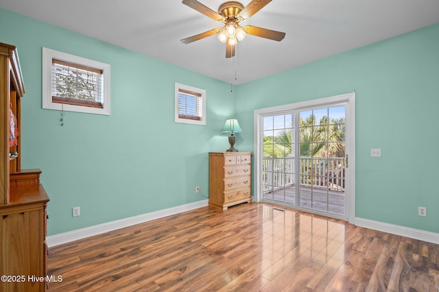 9406 Voyagers Way, Wilmington, NC 28412 - unfurnished bedroom with access to exterior, wood finished floors, and a ceiling fan