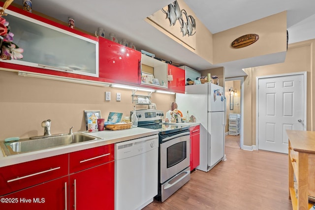 9406 Voyagers Way, Wilmington, NC 28412 - kitchen with white appliances, red cabinets, light wood-type flooring, and light countertops