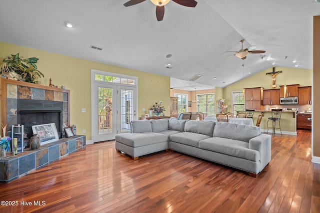9406 Voyagers Way, Wilmington, NC 28412 - living room with ceiling fan, hardwood / wood-style flooring, lofted ceiling, plenty of natural light, and a tiled fireplace