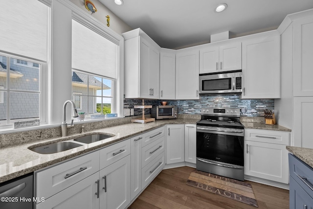 4340 Island Dr, North Topsail Beach, NC 28460 - kitchen featuring stainless steel appliances, white cabinetry, tasteful backsplash, dark wood-type flooring, and recessed lighting