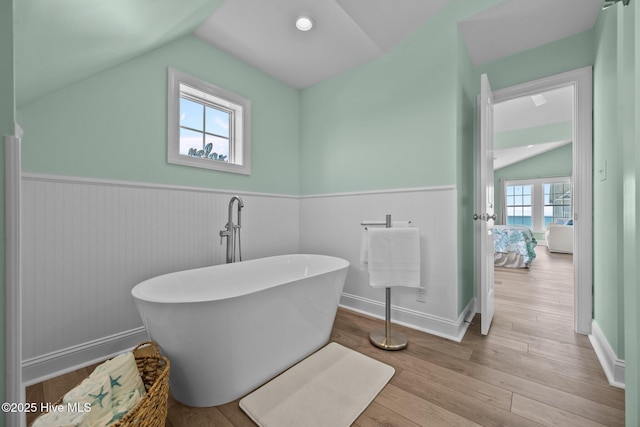 4340 Island Dr, North Topsail Beach, NC 28460 - full bath with lofted ceiling, a freestanding bath, wainscoting, and wood finished floors