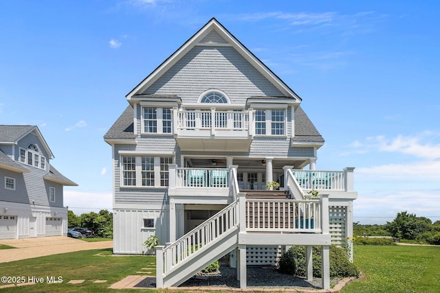 4340 Island Dr, North Topsail Beach, NC 28460 - view of front of house featuring ceiling fan, a balcony, stairs, a front lawn, and a shingled roof