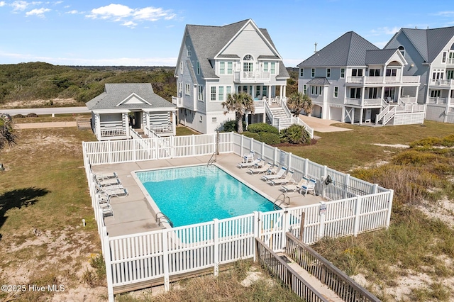 4340 Island Dr, North Topsail Beach, NC 28460 - rear view of property featuring a fenced backyard, a community pool, stairs, a balcony, and a patio area