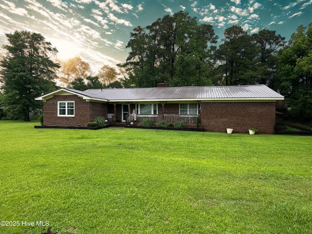 4321 Spearman Rd, Bolton, NC 28423 - single story home featuring a front yard, brick siding, a porch, and a metal roof